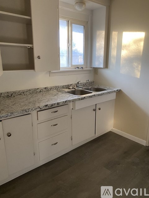 A kitchen with a granite countertop and white cabinets.