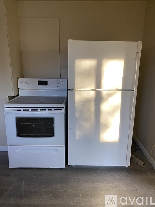 A white fridge and oven in a room.