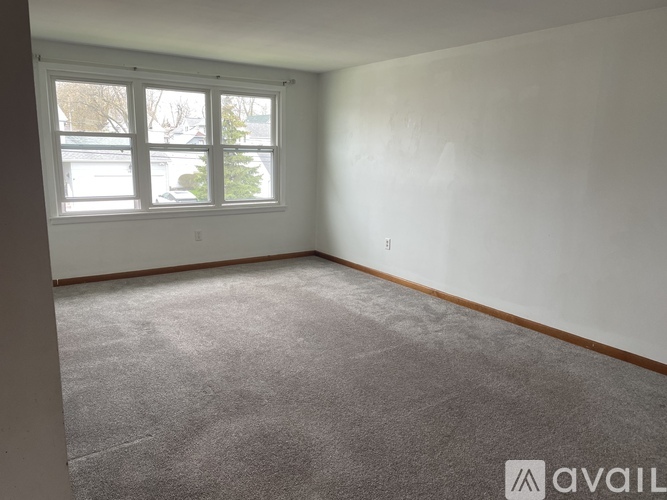 A room with a carpeted floor and a large window.