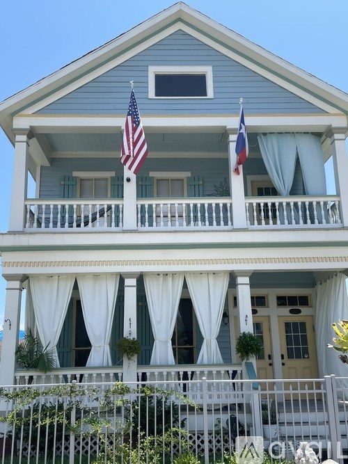 A house with a balcony and two flags on it.