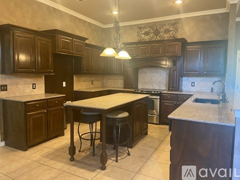 A kitchen with dark wood cabinets and a granite countertop.