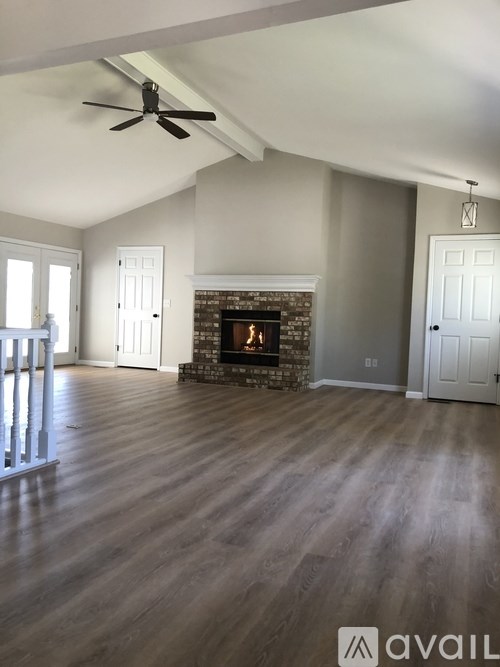 A room with a fireplace and a ceiling fan.