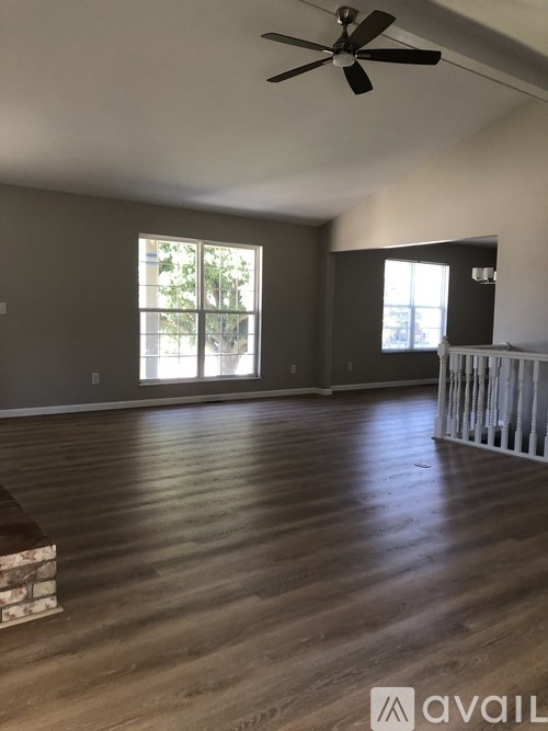 A room with wooden floors and a ceiling fan.