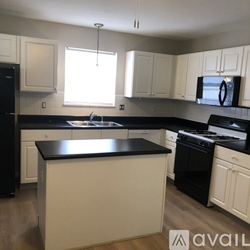 A kitchen with black countertops and white cabinets.