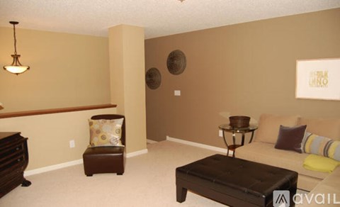 A living room with a brown couch and a brown ottoman.