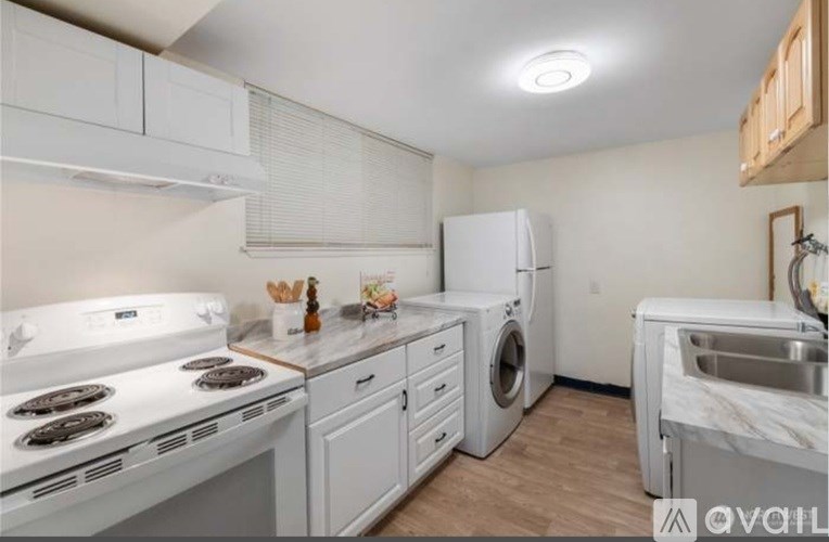A kitchen with white appliances and wooden cabinets.