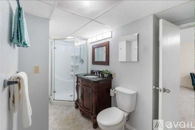 A bathroom with a toilet, sink, and shower.