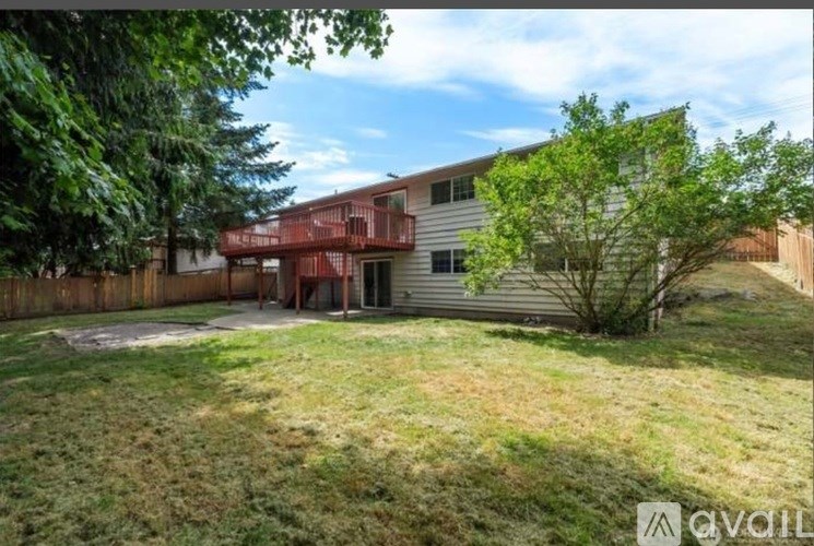A house with a fence and a tree in front of it.