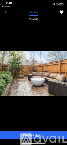 A photo of a backyard with a patio and a hot tub.