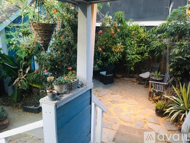 A small patio with a table and chairs surrounded by plants.