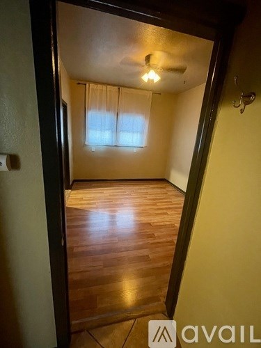 A room with wooden floors and a ceiling fan.