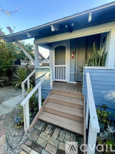 A small house with a porch and a white railing.