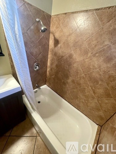 A patio with a pergola and potted plants.