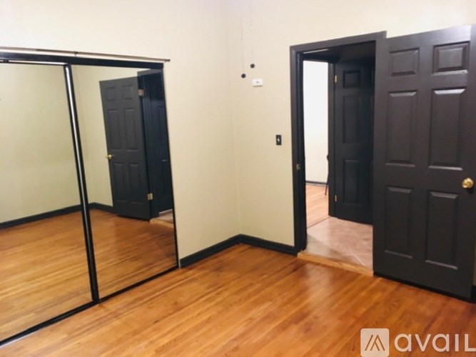 A room with a sliding door, a black door, and a brown door.