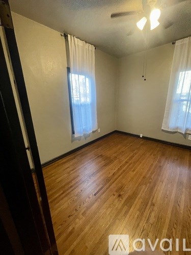 A room with a black door and a fan on the ceiling.