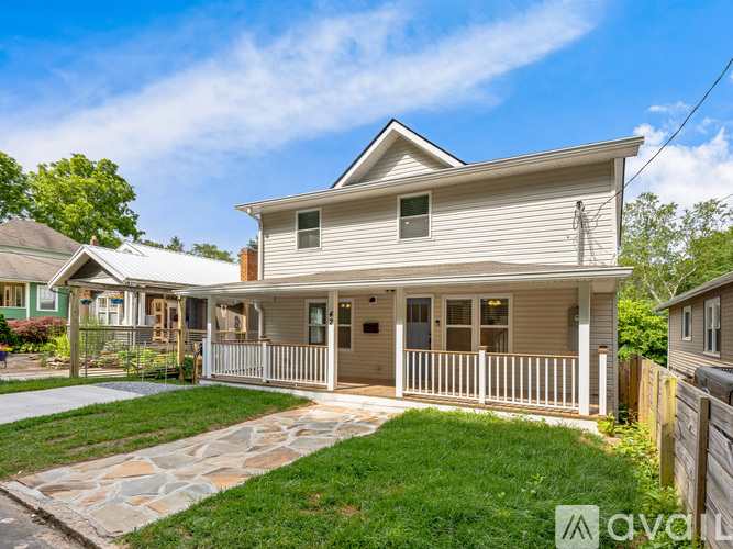 A two-story house with a front porch and a stone walkway.