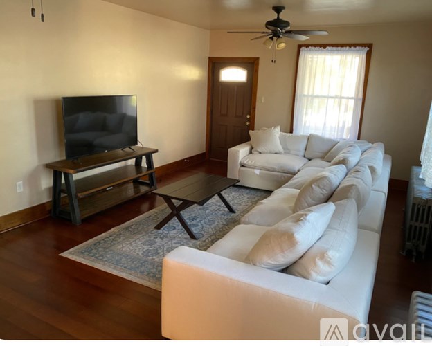 A living room with a white couch and a television.