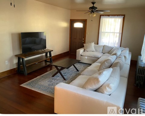 A living room with a white couch and a television.