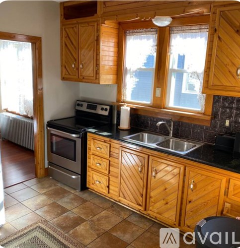 A kitchen with wooden cabinets and a black countertop.