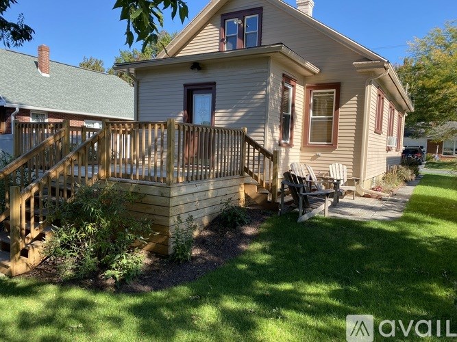 A house with a green lawn and a wooden deck.