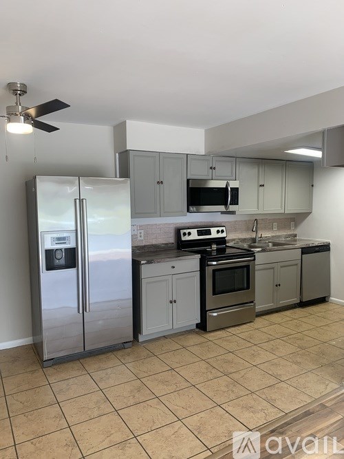 A kitchen with a refrigerator, stove, and microwave.