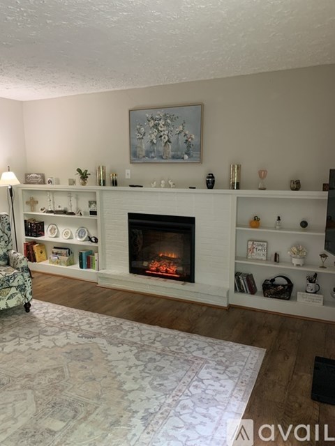 A living room with a fireplace and a painting above it.