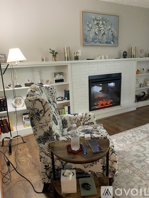 A living room with a fireplace and a painting above it.