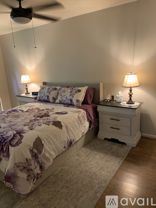 A bedroom with a bed, nightstand, and two lamps.