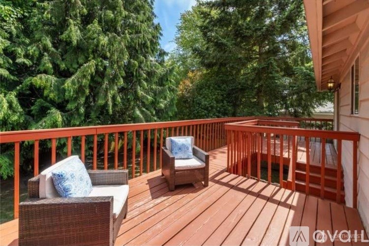 A wooden deck with two chairs and a cushioned bench.