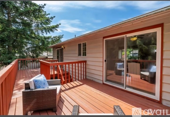 A wooden deck with a couch and chairs on it.