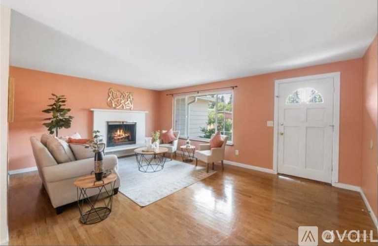 A cozy living room with a fireplace and a Christmas tree.