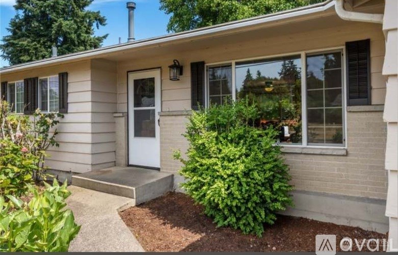 A house with a white door and a small garden in front.