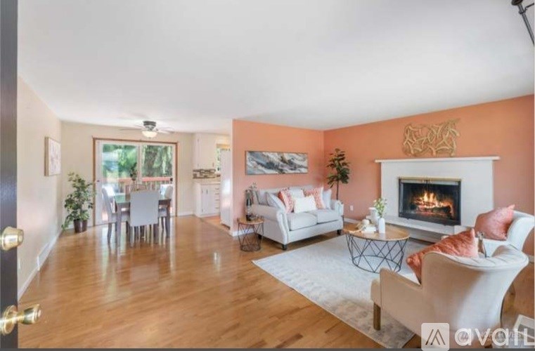 A living room with a fireplace and a dining table.