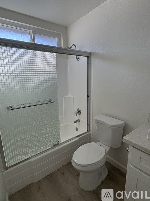 A white toilet in a bathroom with a glass shower door.