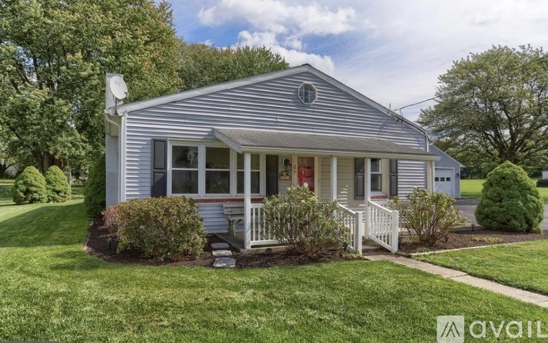 A house with a porch and a white picket fence is for sale.