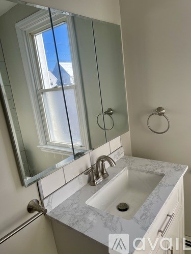 A bathroom with a sink and mirror.