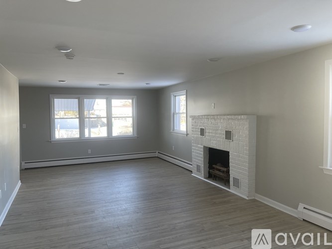 A spacious living room with a fireplace and large windows.