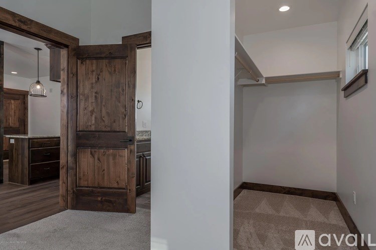 A room with a large wooden door and a carpeted floor.