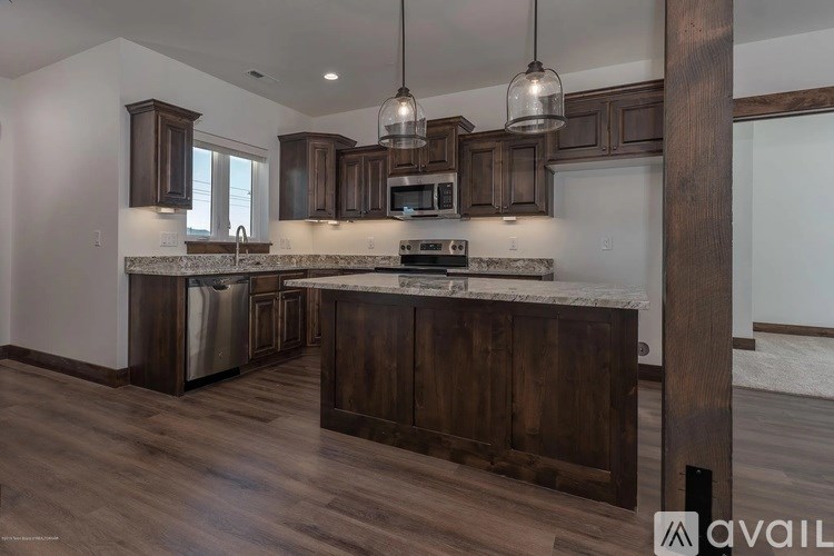 A kitchen with dark wood cabinets and a white countertop.