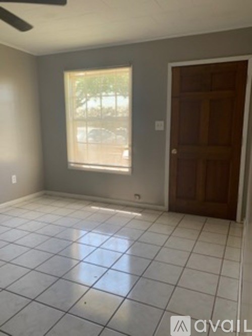 A room with a tiled floor and a window letting in natural light.