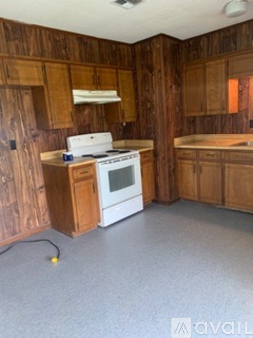 A kitchen with wooden cabinets and a white oven.