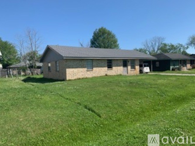 A house with a grey roof and a white car parked in front.