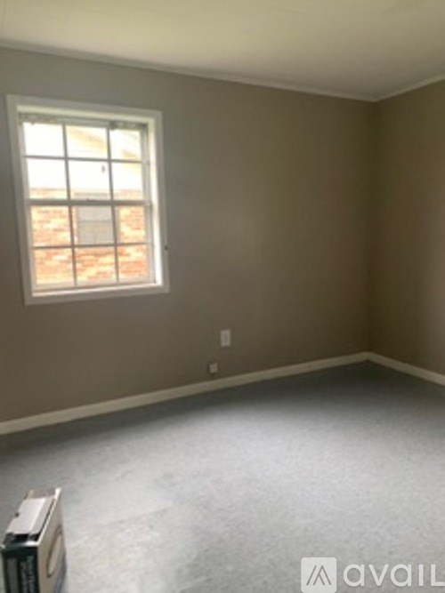 A room with a window and a wall socket.