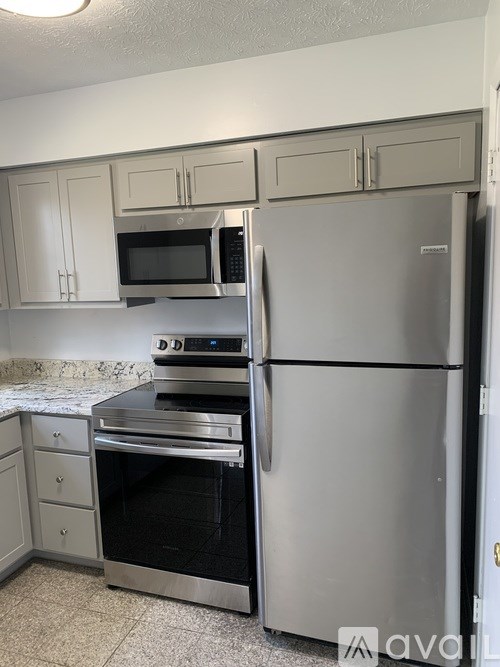 A kitchen with a stainless steel refrigerator, oven, and microwave.
