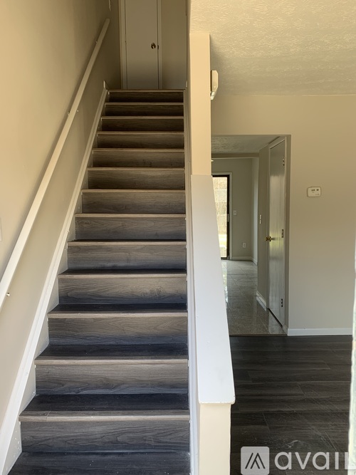 A staircase with wooden steps and white railings.