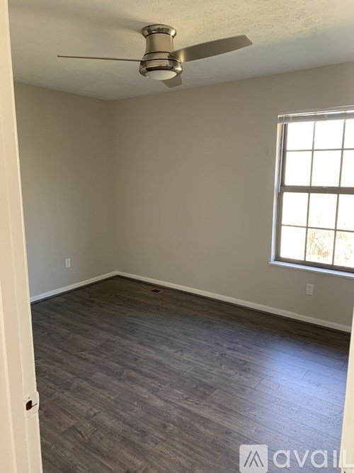 A room with a ceiling fan and a window.