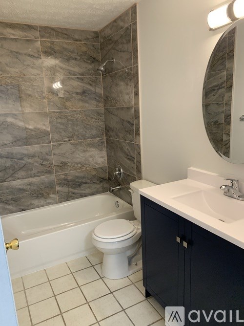A bathroom with a toilet, sink, and tiled walls.
