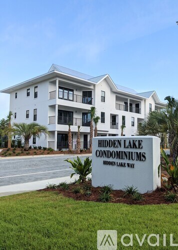 A sign for Hidden Lake Condominiums in front of a building.