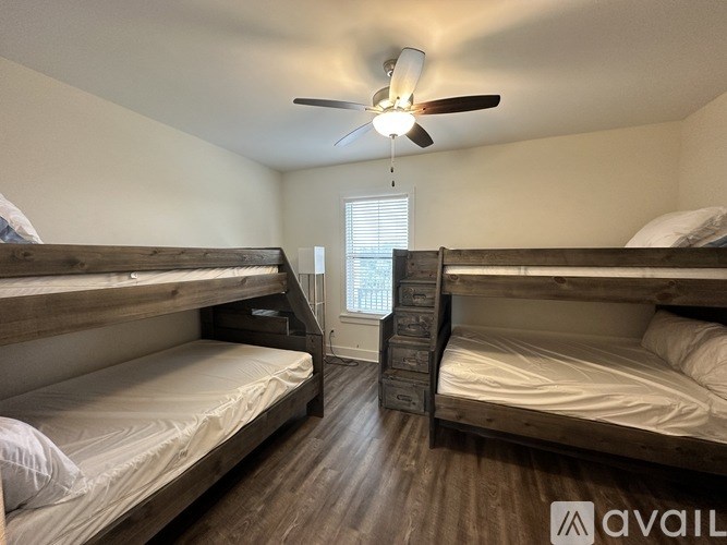 A room with two bunk beds and a ceiling fan.