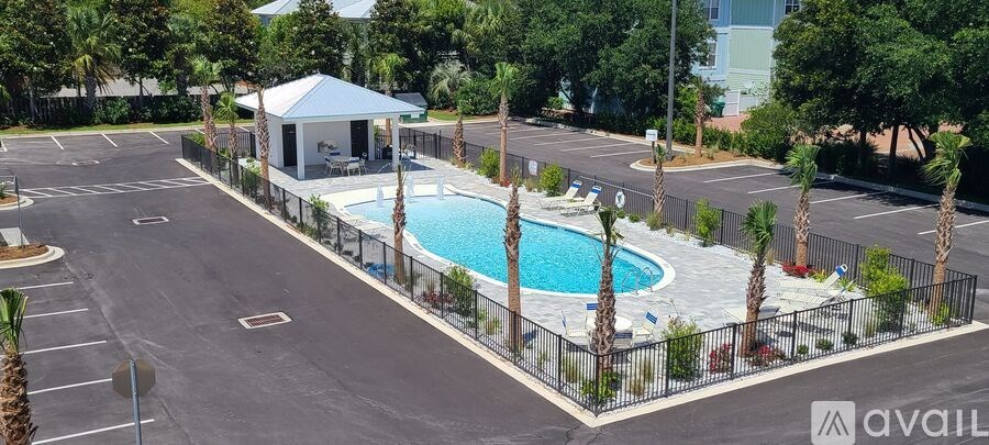 A pool surrounded by a black fence with a gazebo in the middle.